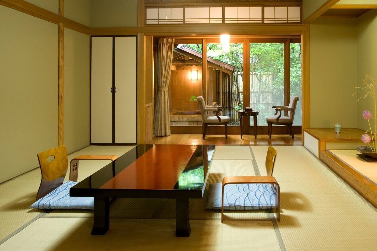 Ein traditioneller japanischer Raum mit Tatami-Böden, einem niedrigen Tisch und Schiebetüren.
