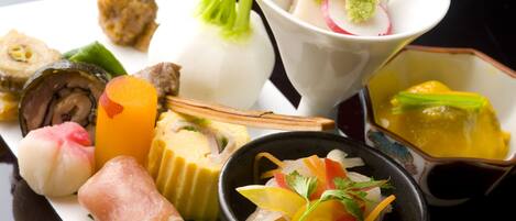 A variety of Japanese dishes including sushi, sashimi, and a bowl of pickled vegetables.