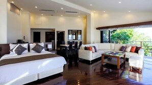 A hotel room with a bed, a sofa, a coffee table, and a balcony with a view. - Hyakuna Garan (Nanjo)