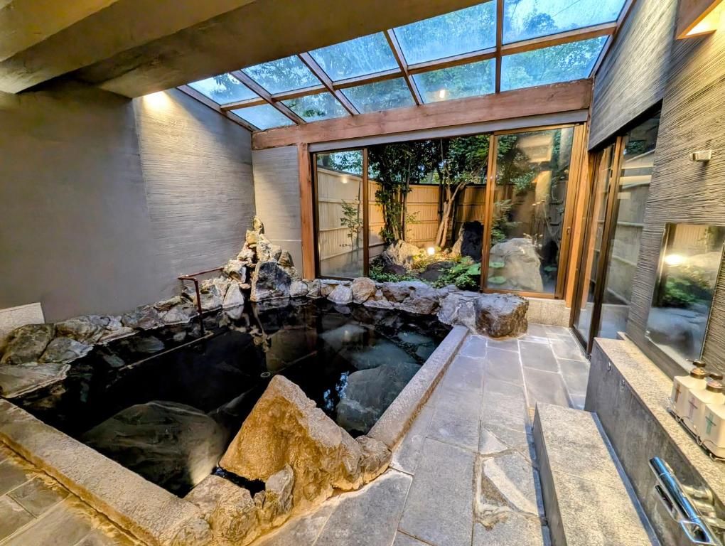 Uma área de spa com hidromassagem, paredes de pedra e teto de vidro.