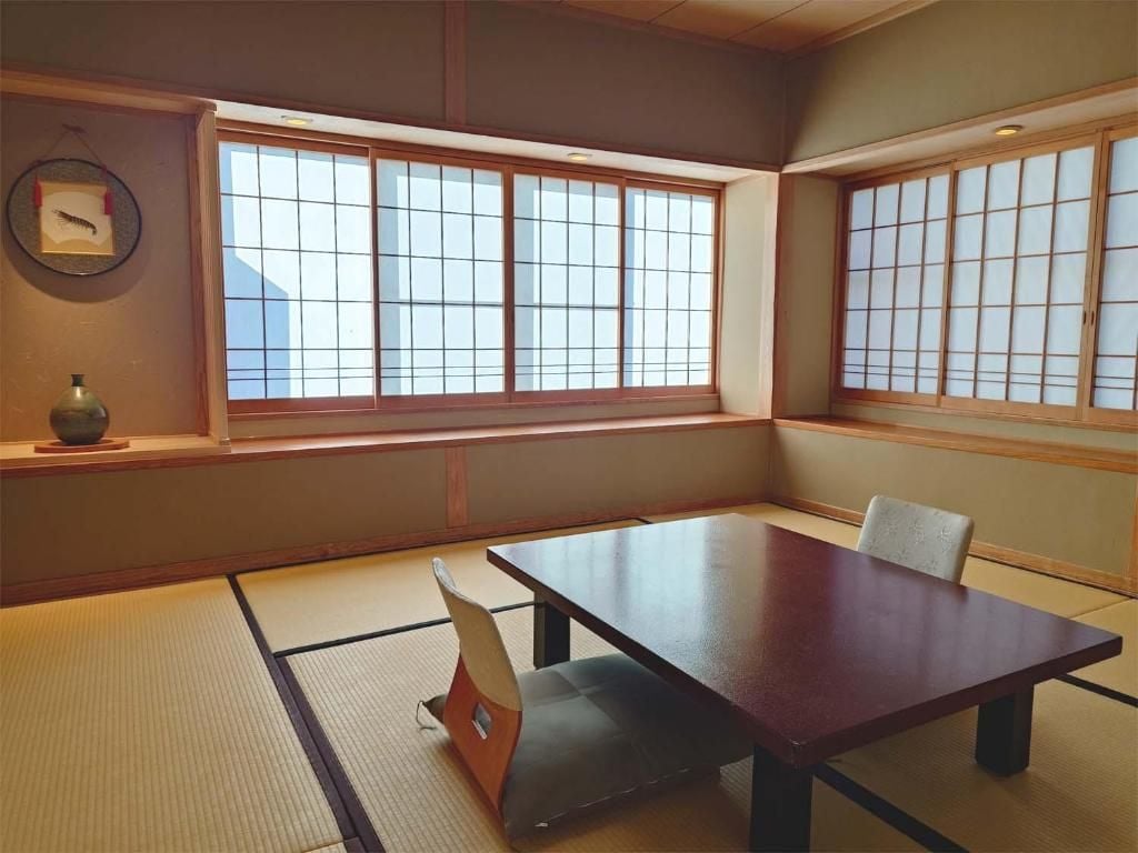 Una tradizionale stanza giapponese con pavimento in tatami, un tavolino basso e porte scorrevoli shoji.
