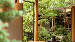 Un intérieur de style japonais traditionnel, avec un sol recouvert de tatamis, un banc en bois, une petite table et une lanterne.