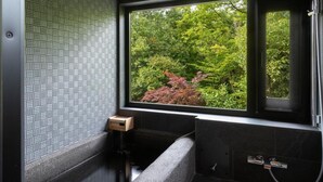 Une salle de bain moderne dotée d’une grande fenêtre, d’un banc intégré et d’un porte-serviettes.