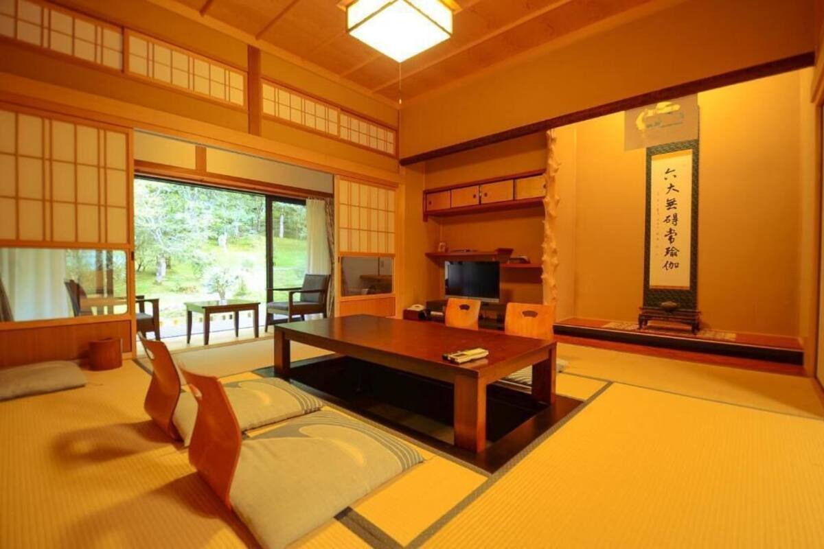 A traditional Japanese room with tatami flooring, a low table, and sliding doors.