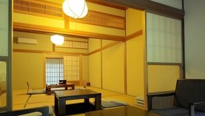 A traditional Japanese room with tatami flooring, a low table, and a sofa. - Fudou-in (Koya)