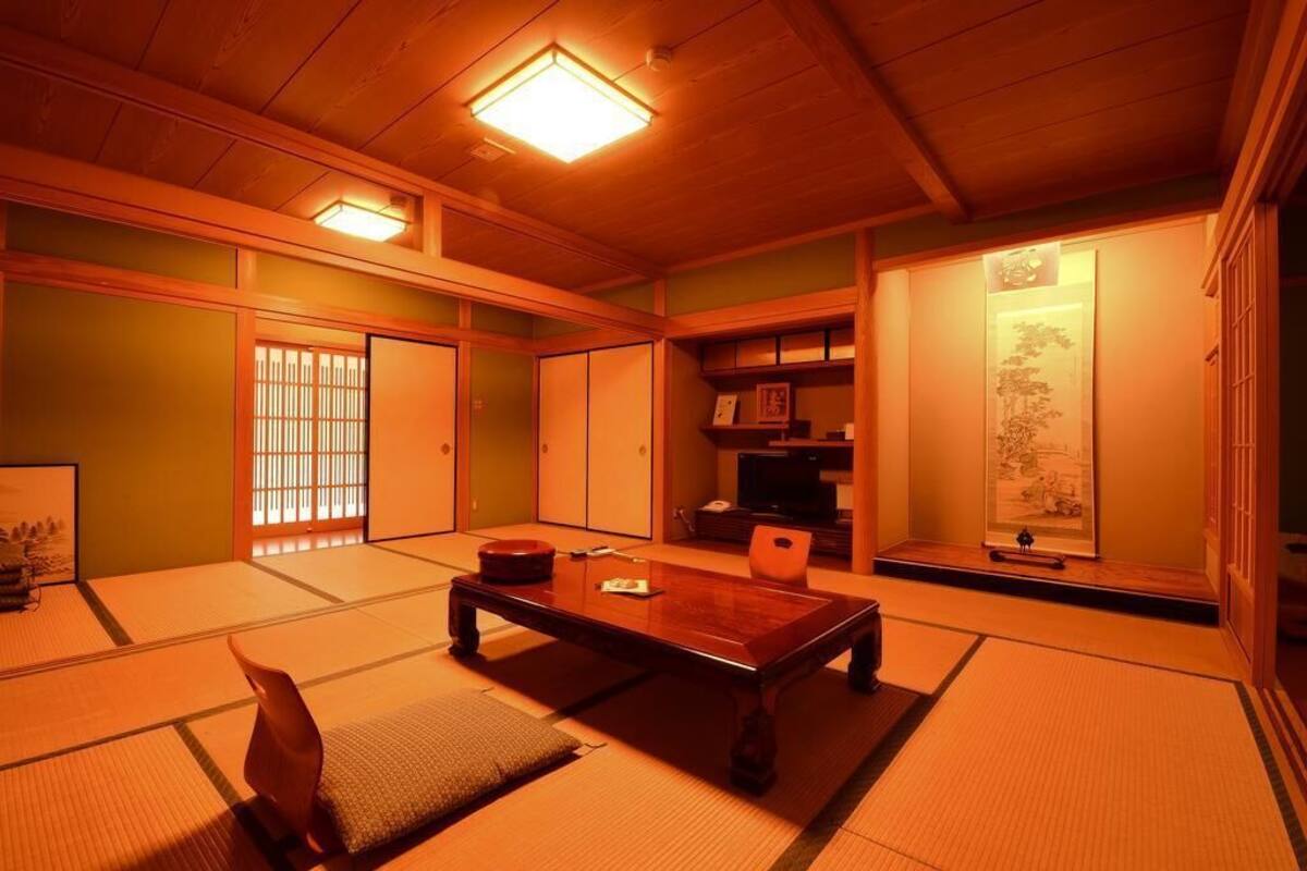 A traditional Japanese room with tatami flooring, a low wooden table, sliding doors, and a shoji screen.