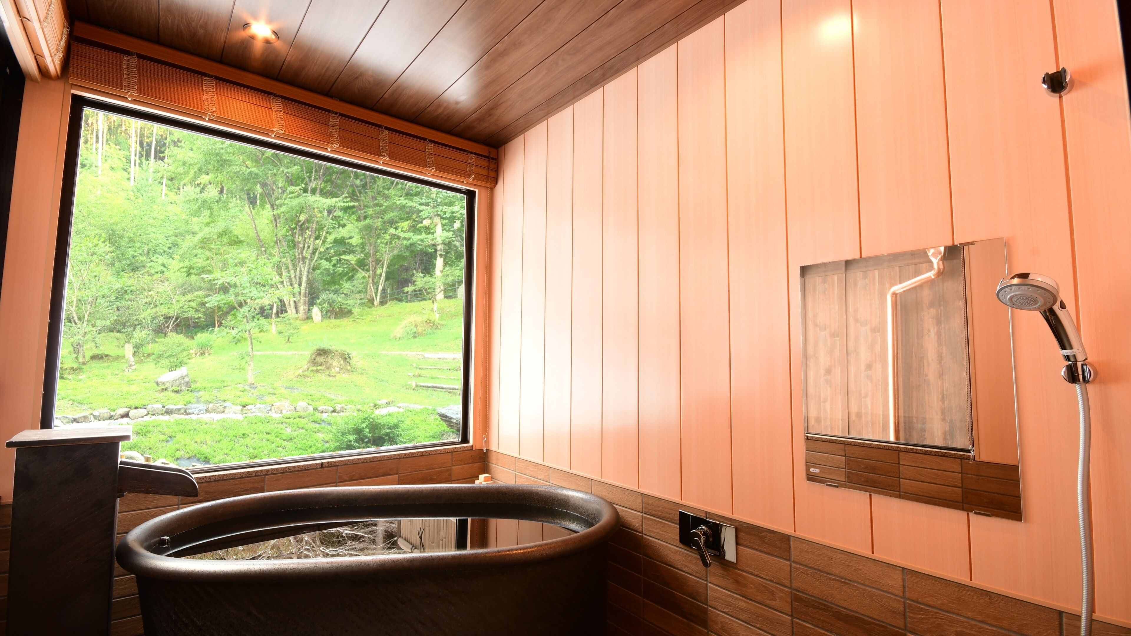 A bathroom with a large window, a bathtub, and a shower.