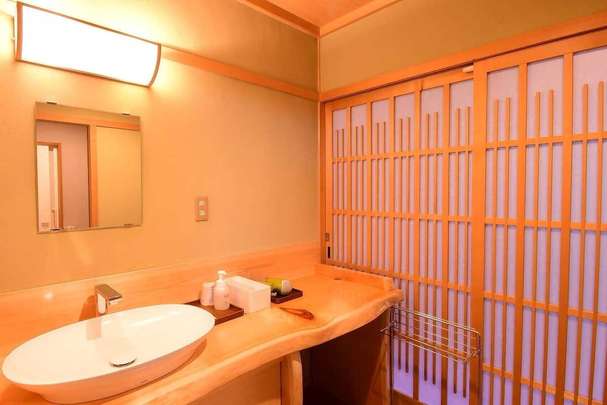 A hotel bathroom with a sink, mirror, and towel rack.