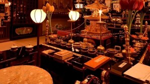 A traditional interior with wooden beams, hanging lanterns, and a central ornate structure. - Fudou-in (Koya)