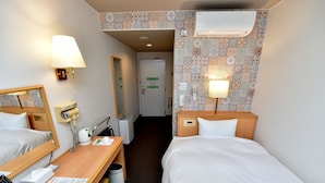 A hotel room with two beds, a desk with a lamp, a mirror, a hairdryer, a trash bin, and a wall-mounted air conditioner. - Idaimae Green Hotel (Saga)