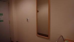 A room with a door, a wall-mounted mirror, and a small table with a chair. - Idaimae Green Hotel (Saga)