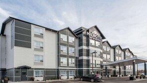Un hotel Microtel by Wyndham con un diseño moderno, que cuenta con estacionamiento techado y varios pisos.