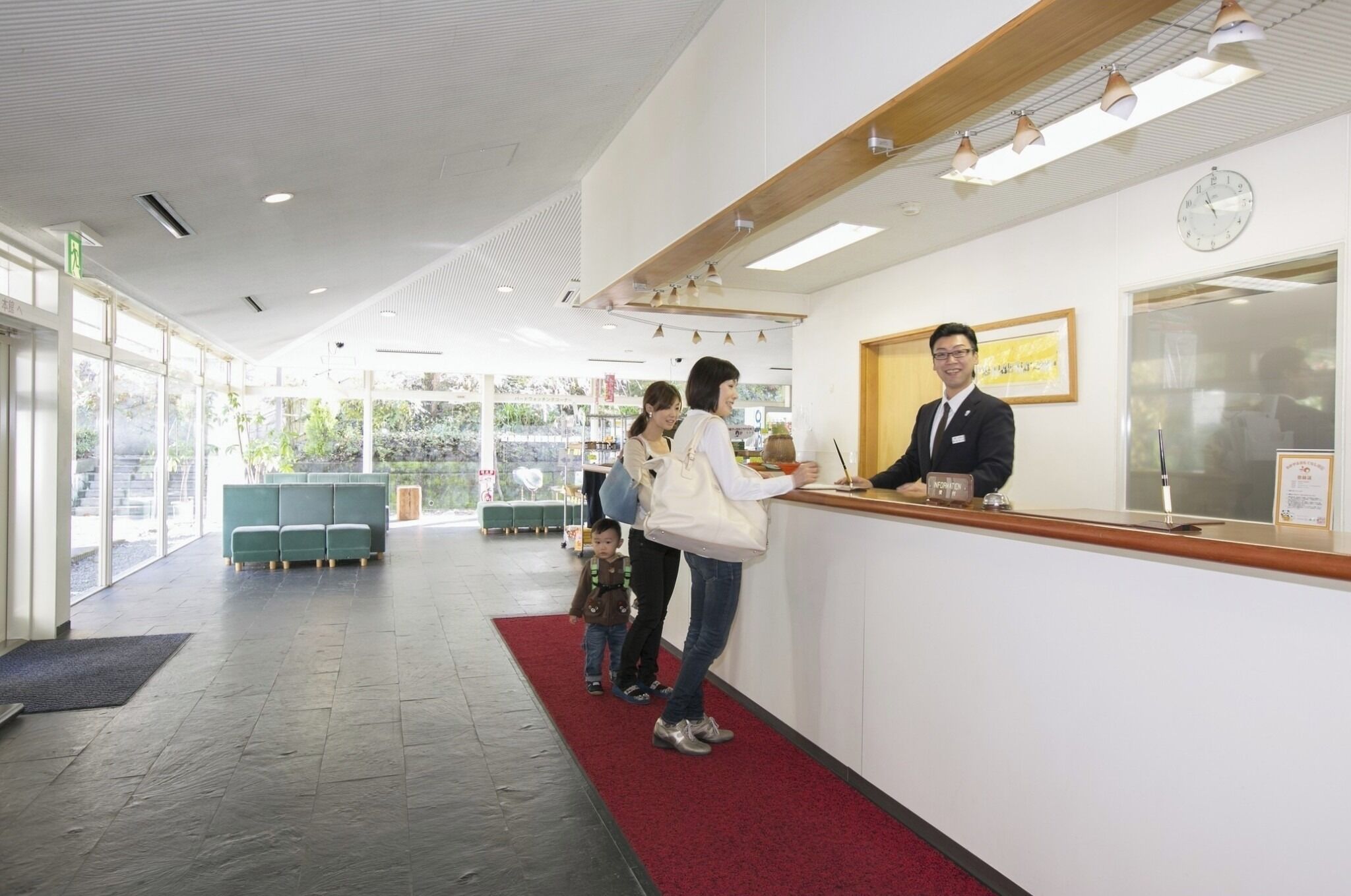 A reception area with a receptionist, a family, and a child.