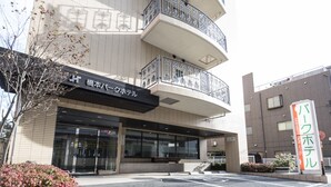 A hotel with a modern design, featuring a prominent entrance, a balcony on the second floor, and a sign indicating it is the Hashimoto Park Hotel. - Hashimoto Park Hotel (Sagamihara)