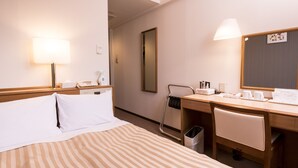 A hotel room with a bed, a desk, a chair, a trash bin, a mirror, and a lamp. - Hashimoto Park Hotel (Sagamihara)