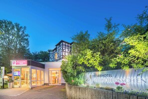 Een hotelentree met een bordje voor 'Best Western PLUS' en 'Ostseehotel Waldschlosschen'.