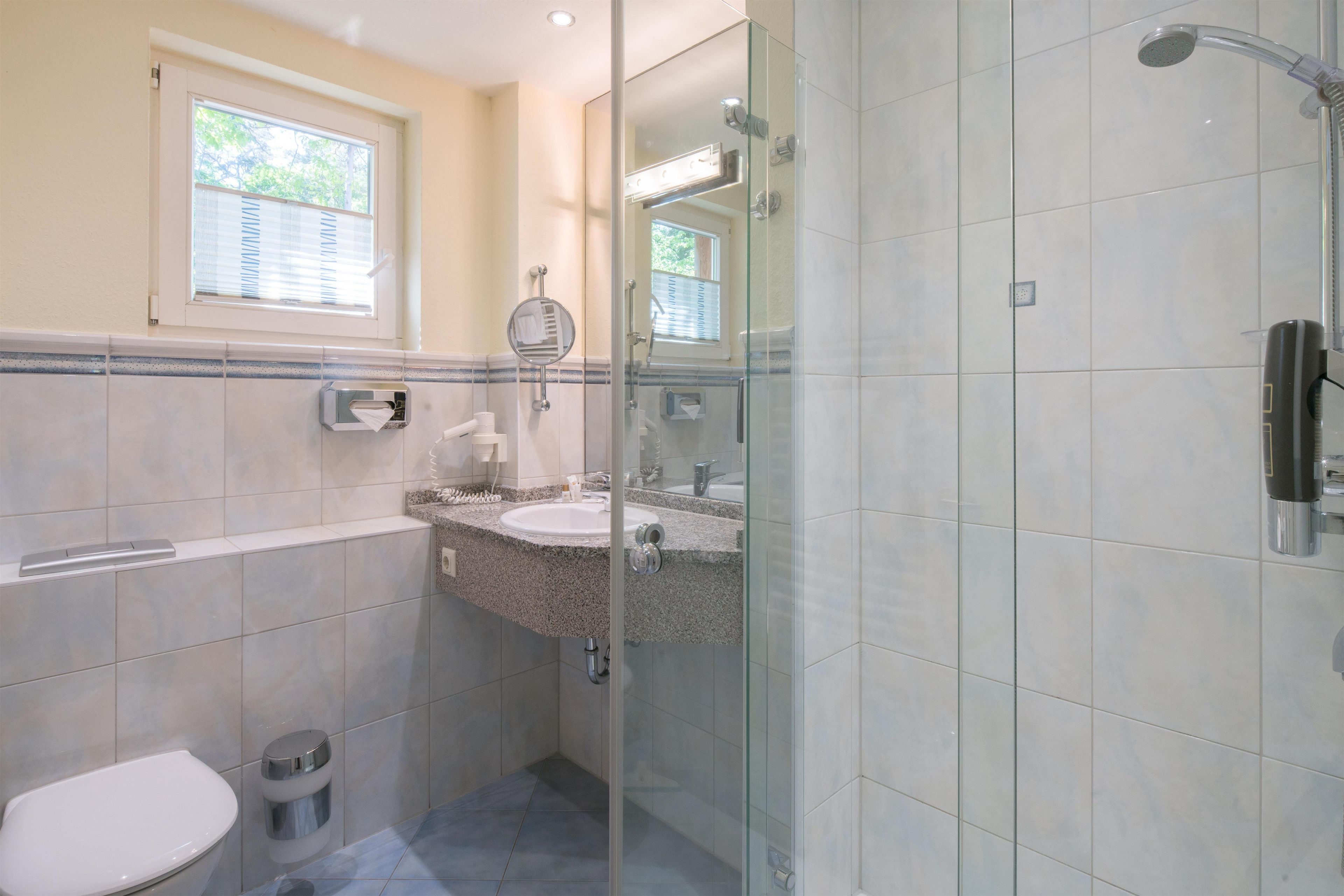 Ein Badezimmer mit Toilette, Waschbecken und Dusche.