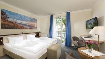 A hotel room with a large bed, a desk with a chair, a window with curtains, and a painting on the wall.