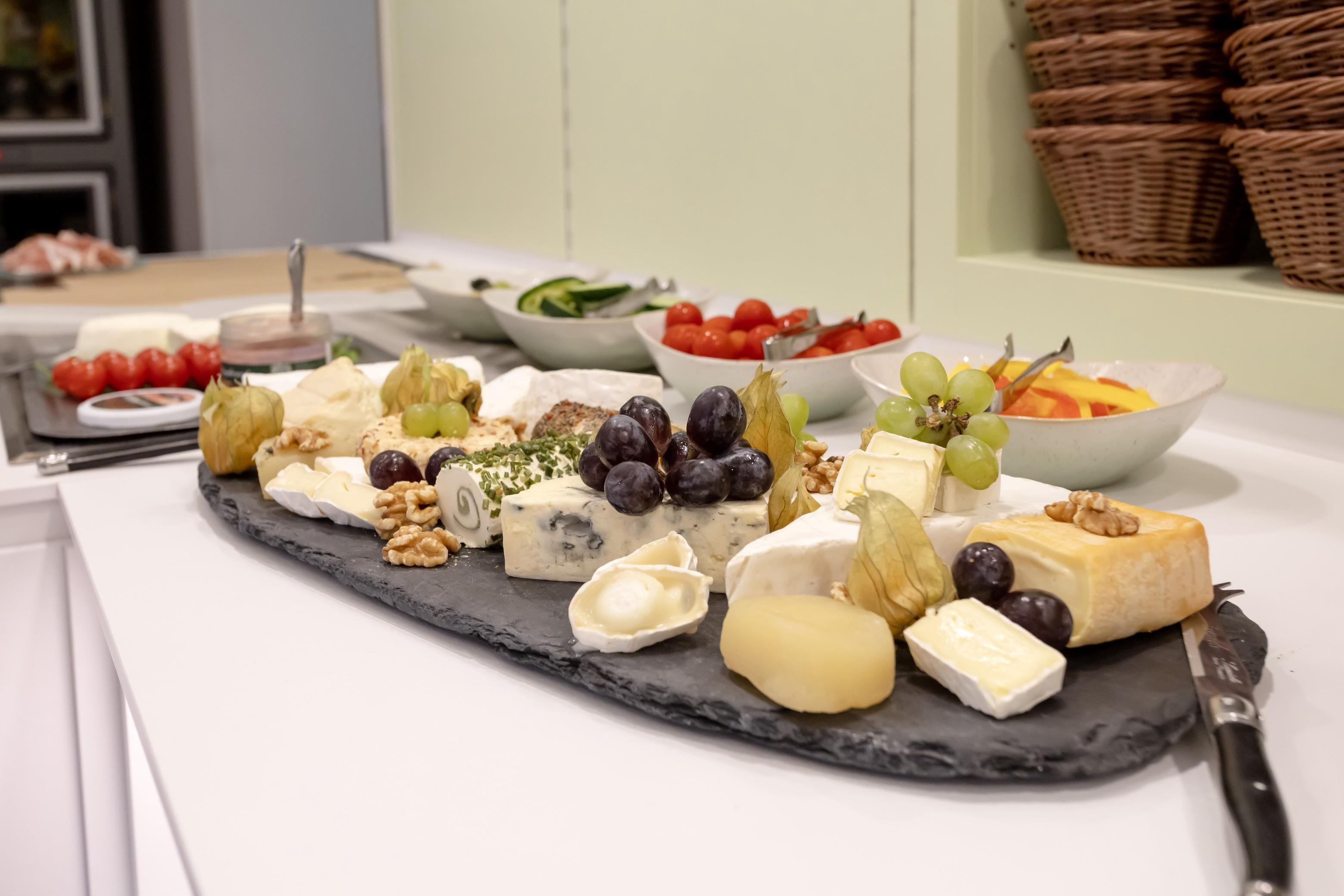 Un plateau de fromages comprenant différents types de fromages et des accompagnements.