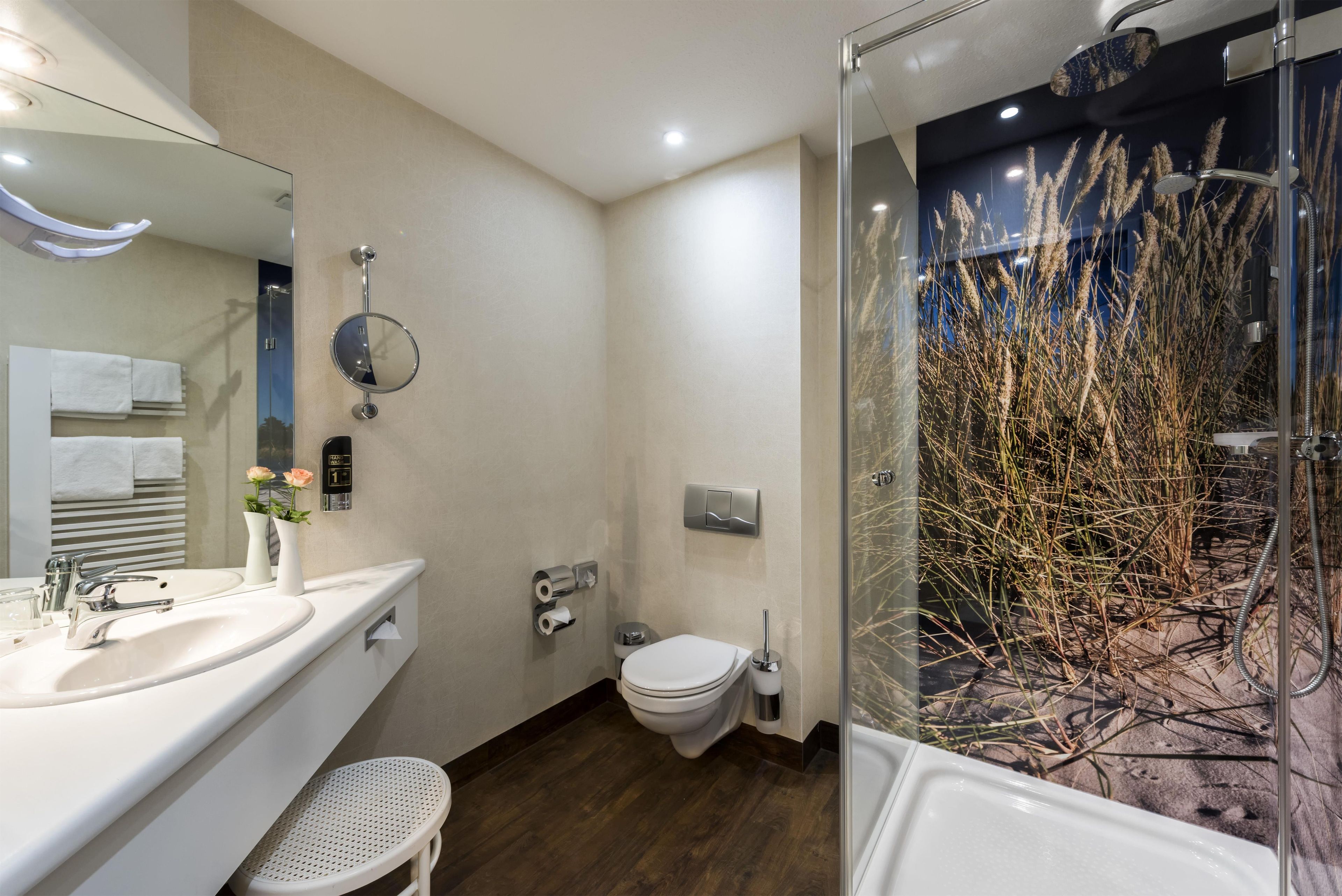 Un baño moderno con ducha, inodoro y lavabo.