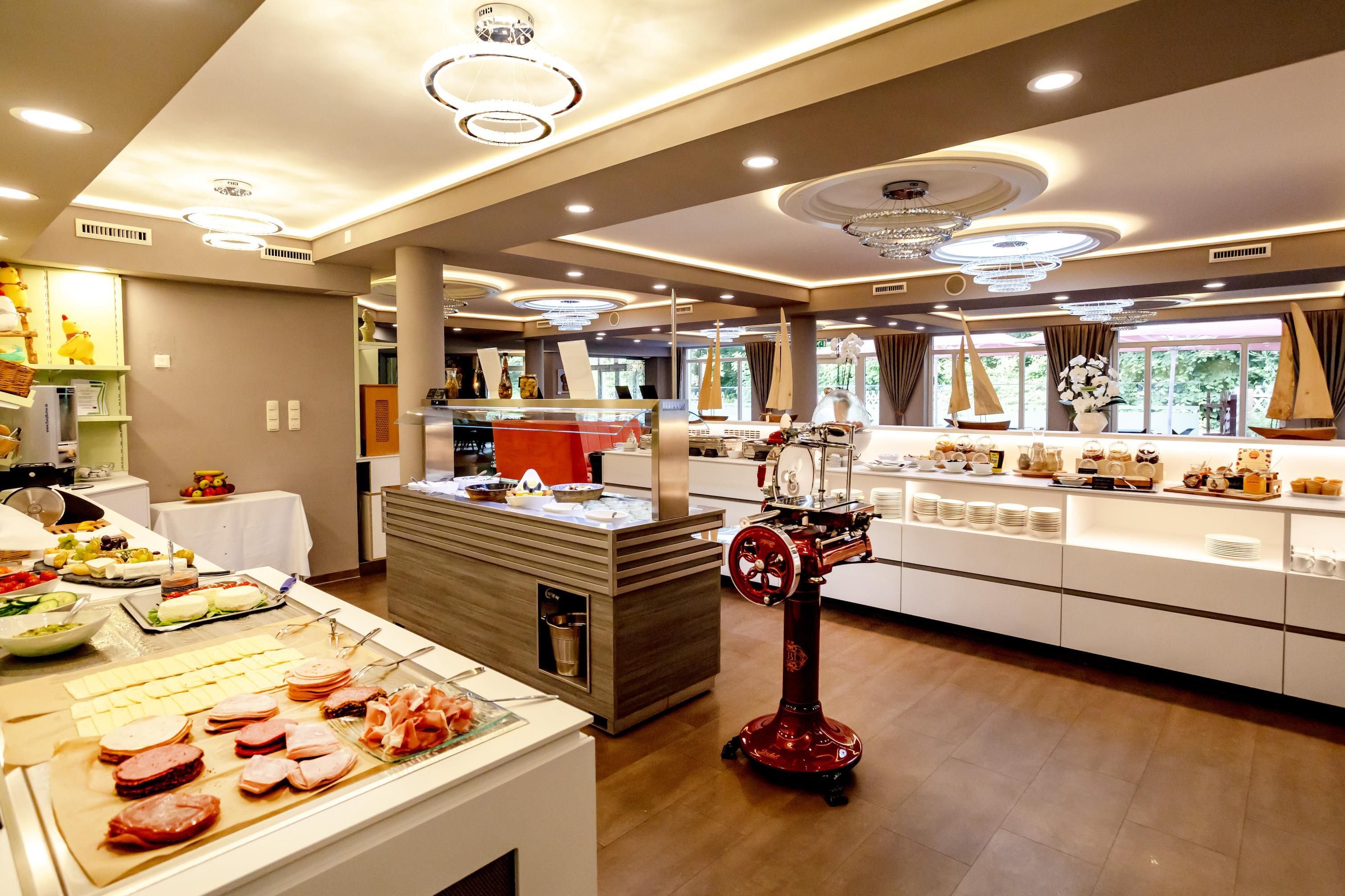 Een buffetopstelling met diverse gerechten, een vleesschaarstation en een decoratieve rode standaard.