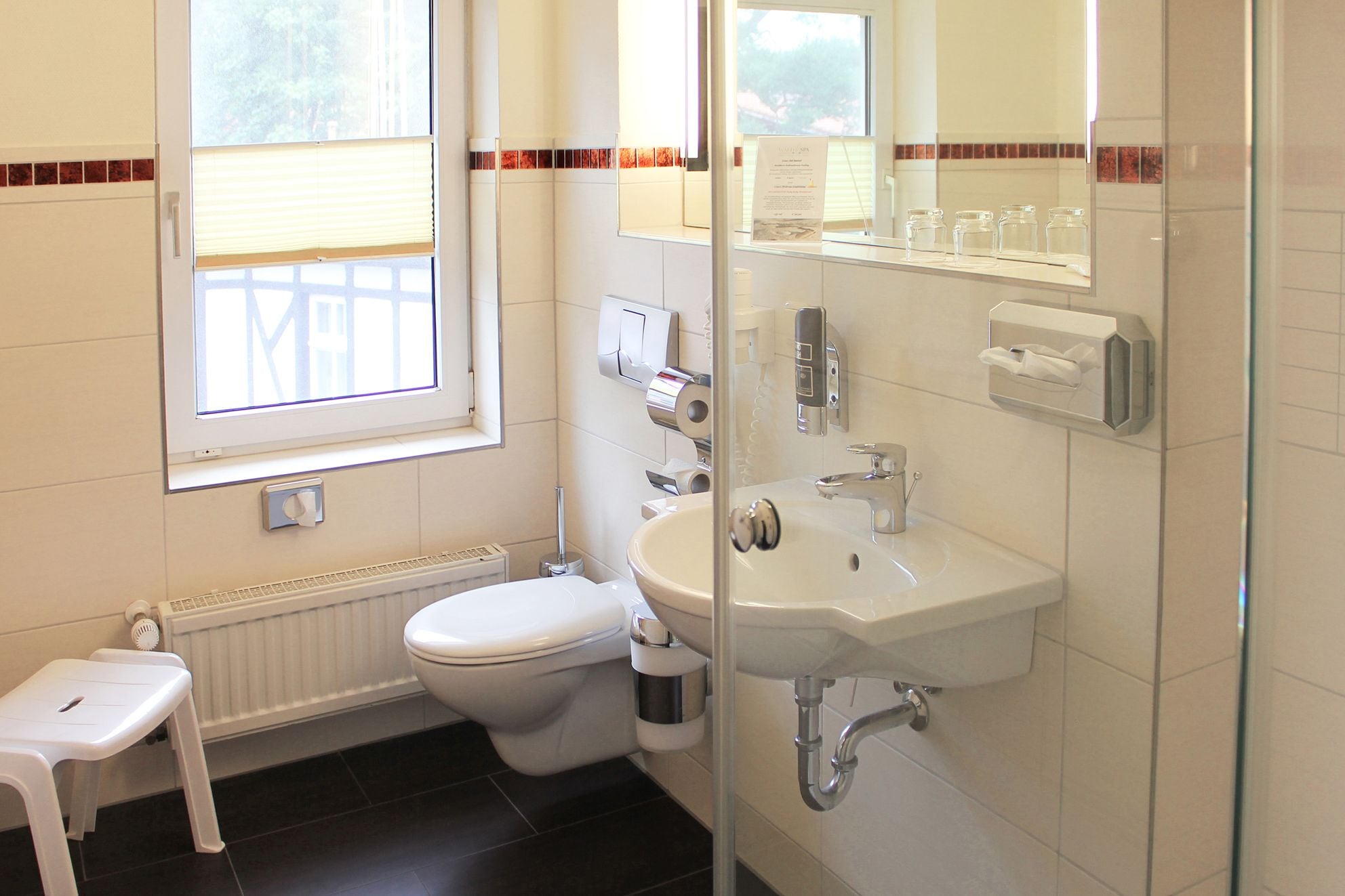 Een moderne badkamer met toilet, wastafel en douche.