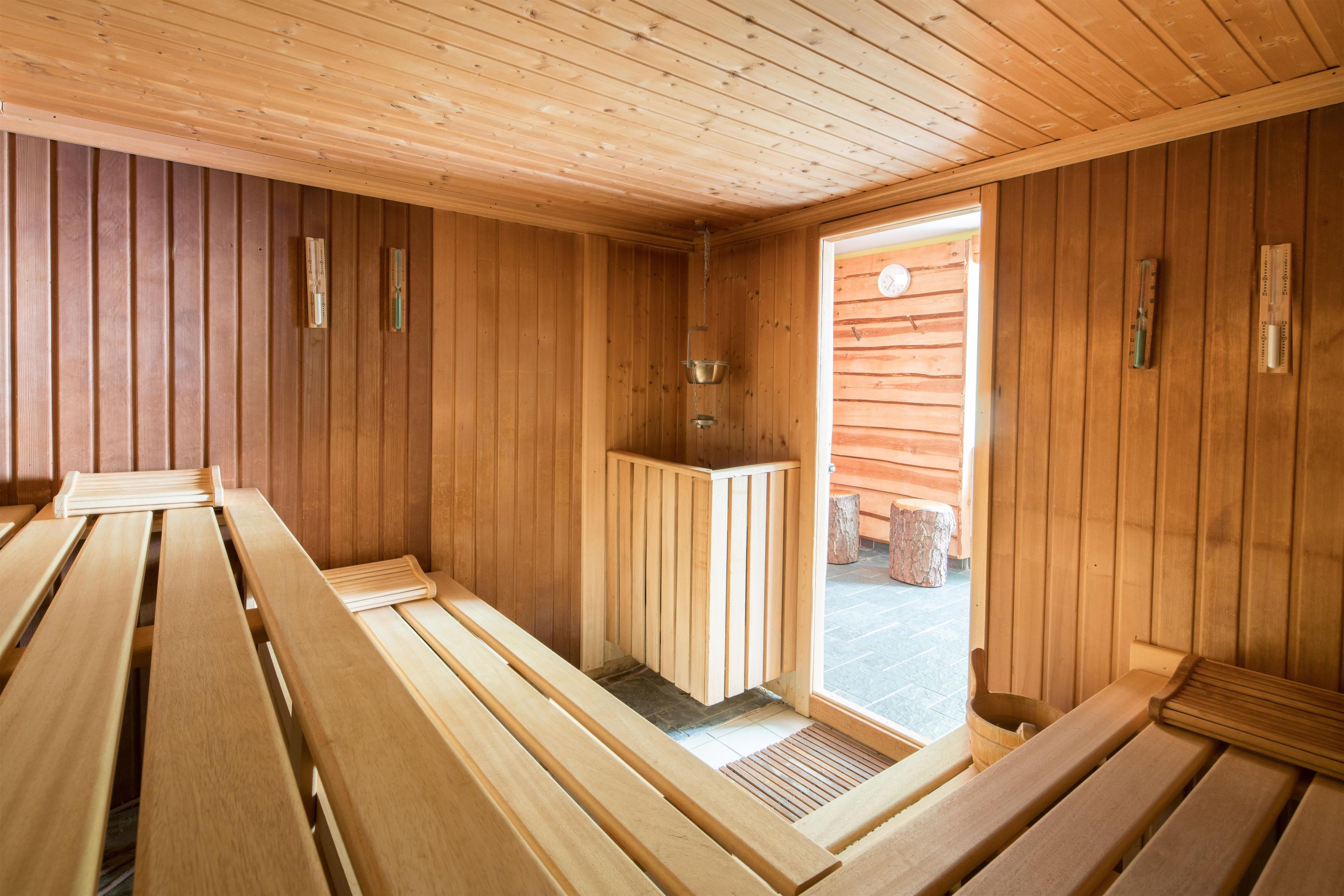 A sauna room with wooden benches and a bench heater.