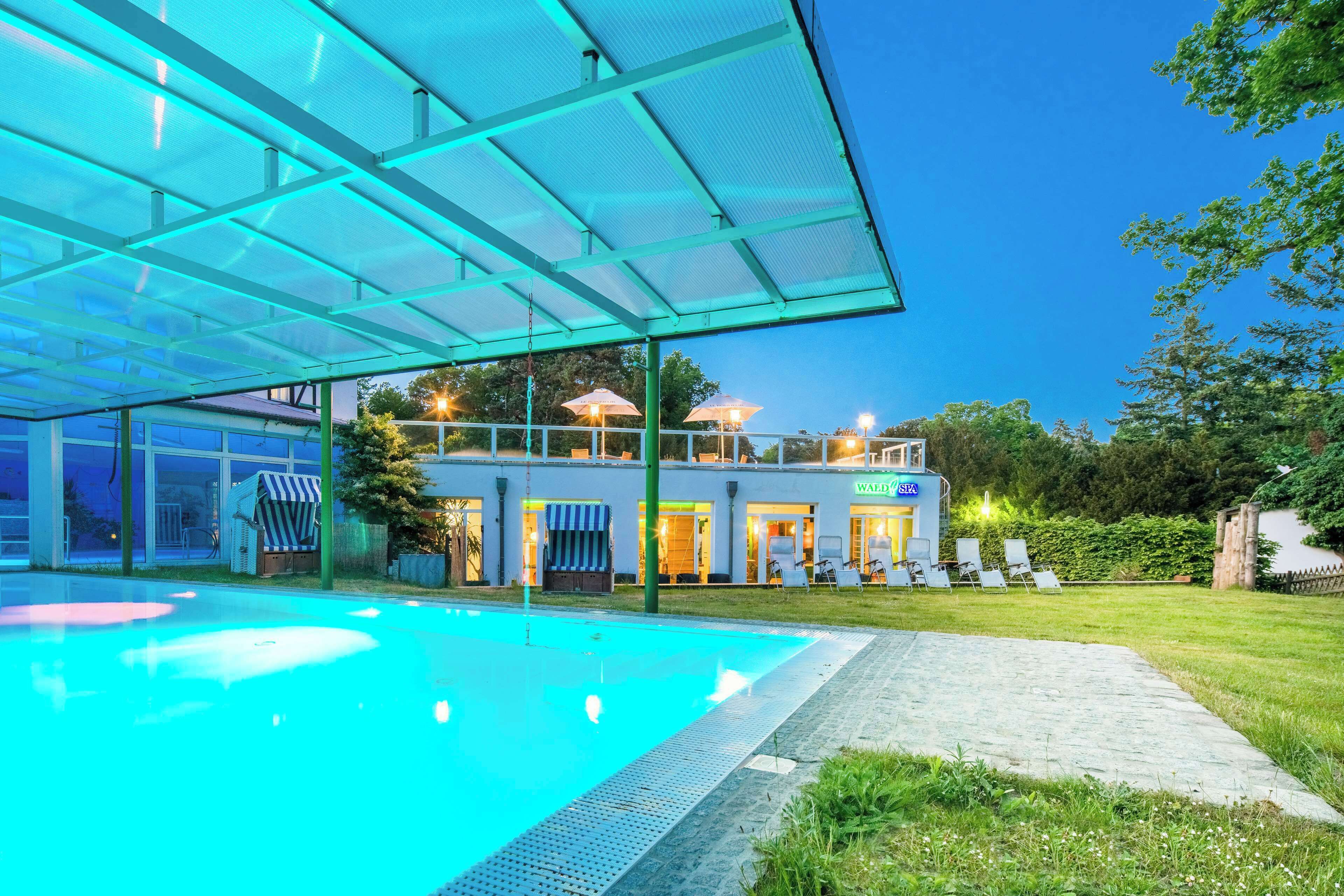 Een binnenzwembad, een buitenzwembad en parasols bij het zwembad