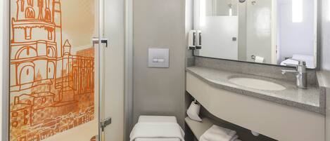 Une salle de bain moderne avec des toilettes, un lavabo et un miroir.