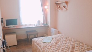A hotel room with a bed, a desk with a computer, a chair, a small table, and a window with curtains. - Good Inn Kagoshima (Kagoshima)