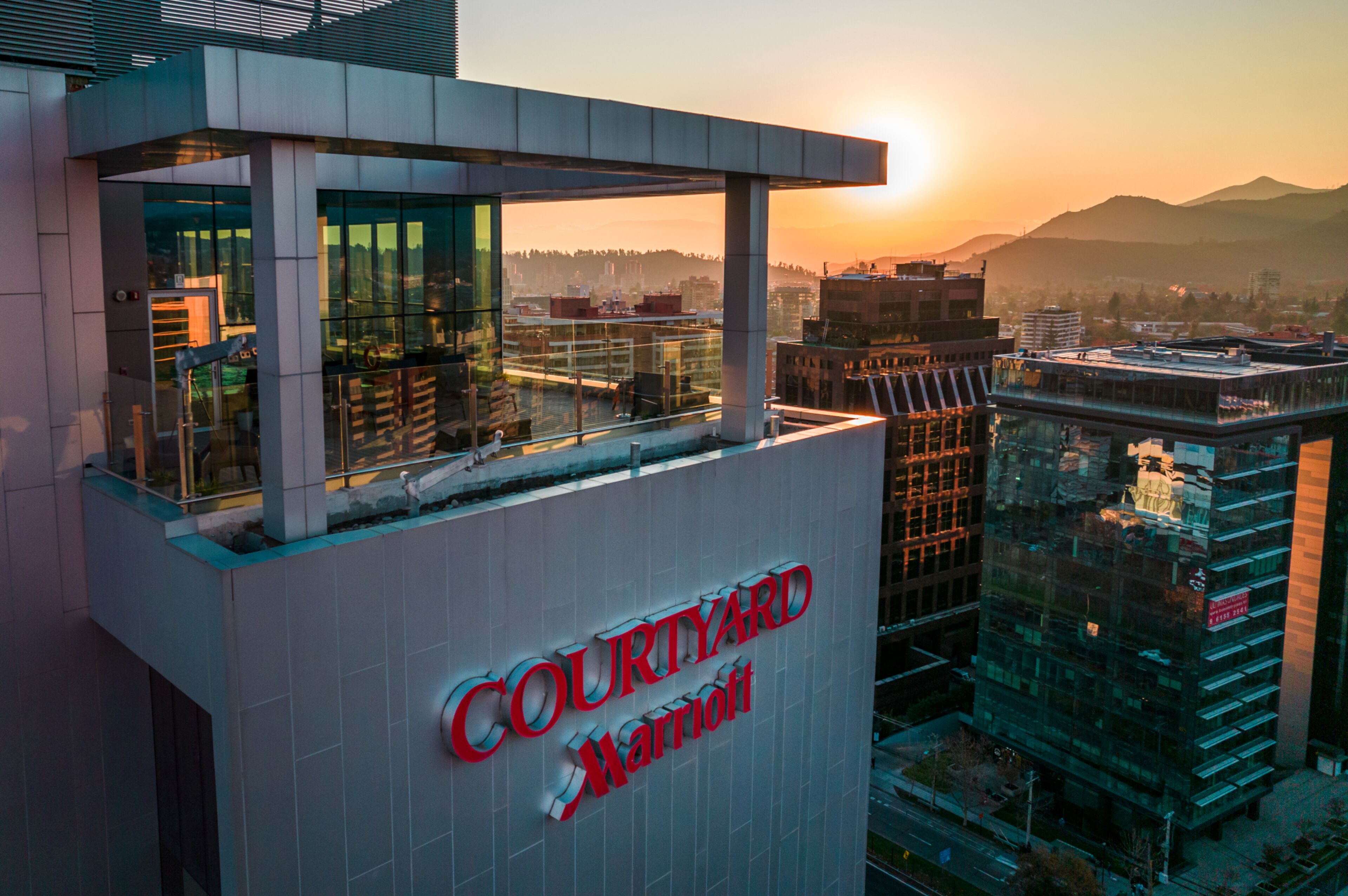 Un edificio moderno con fachada de vidrio y un letrero que dice 'Courtyard Marriott'.