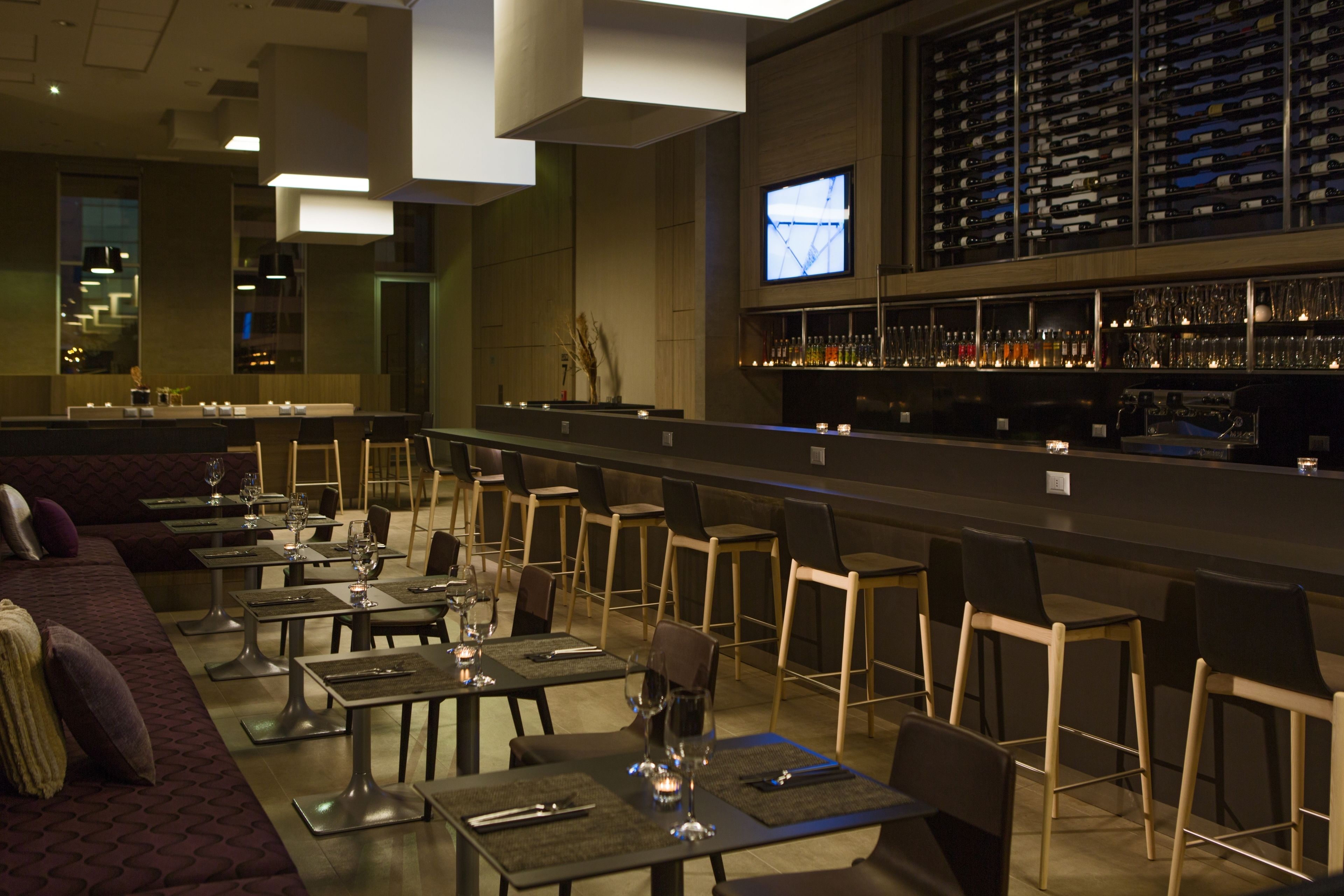 Un restaurante con barra, mesas y sillas.