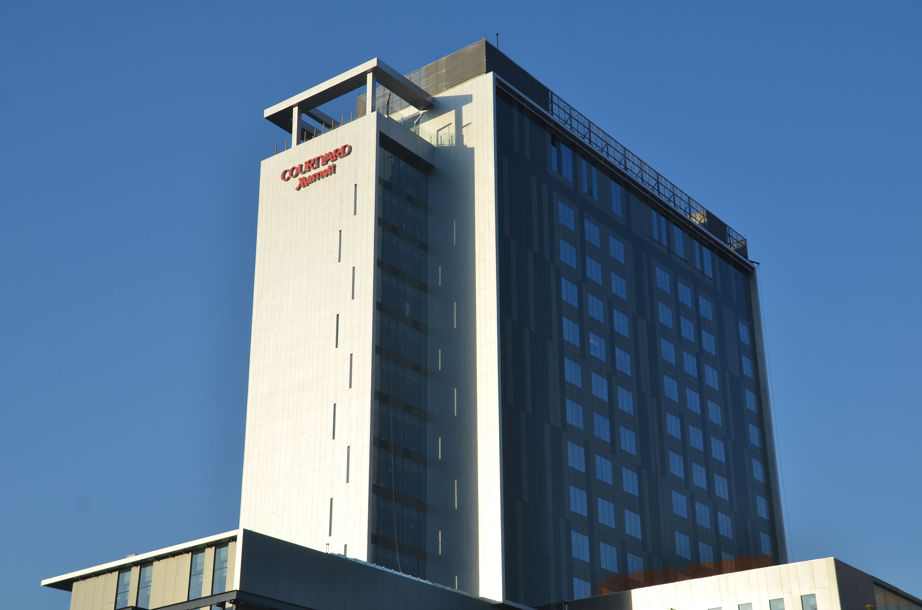 A tall hotel building with a prominent sign reading "Courtyard by Marriott."
