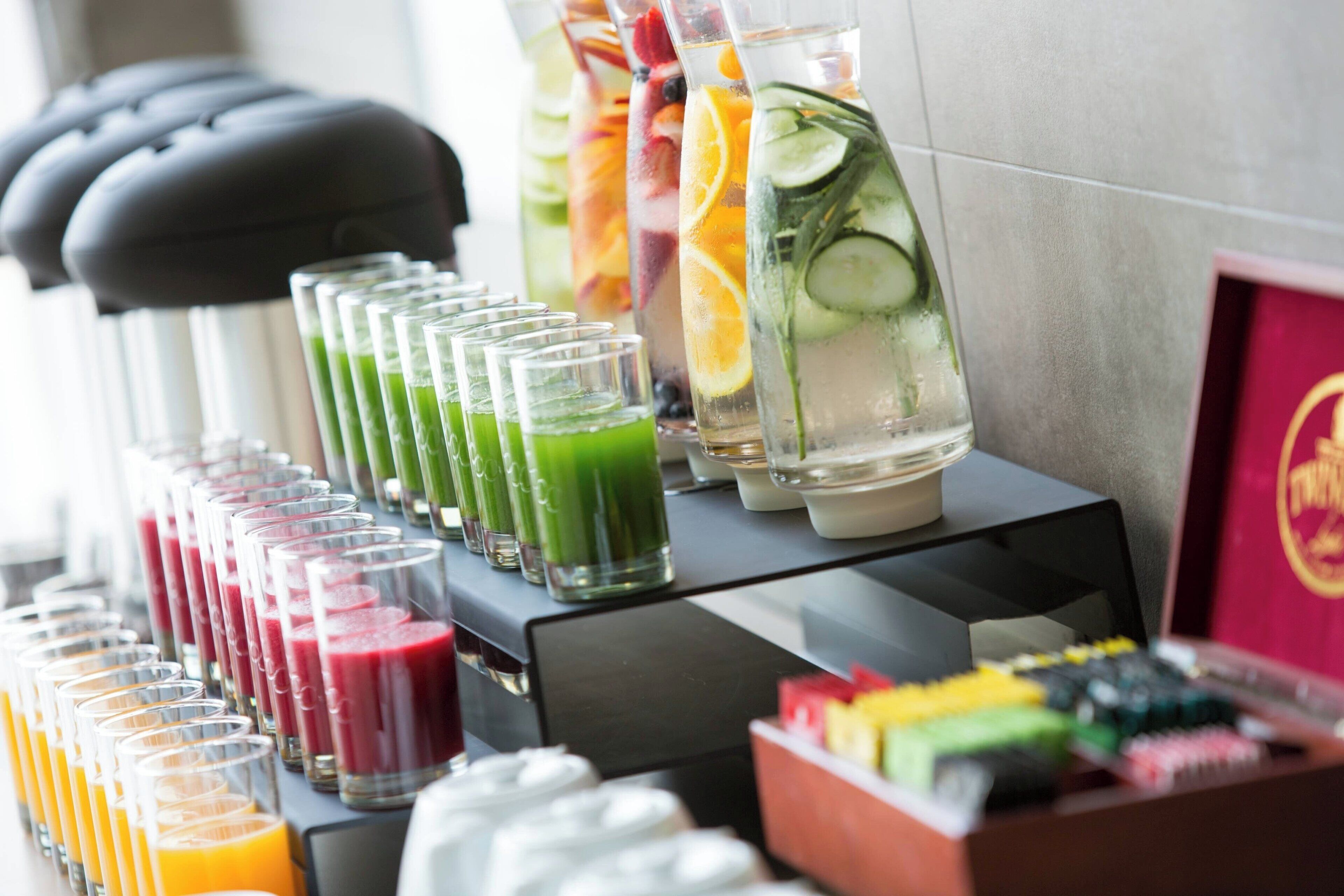 A beverage station with various drinks and a selection of ice cubes.