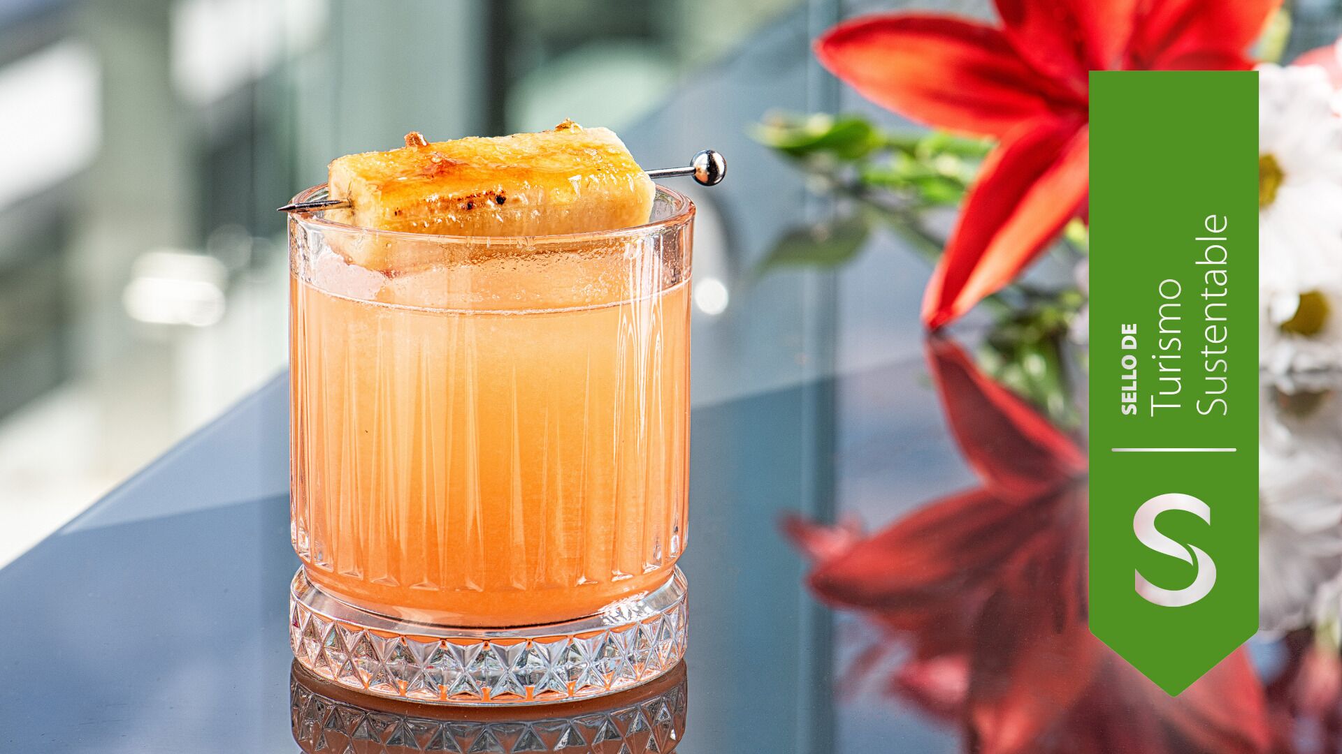 Ein Cocktailglas mit einer Garnitur auf einer spiegelnden Oberfläche.