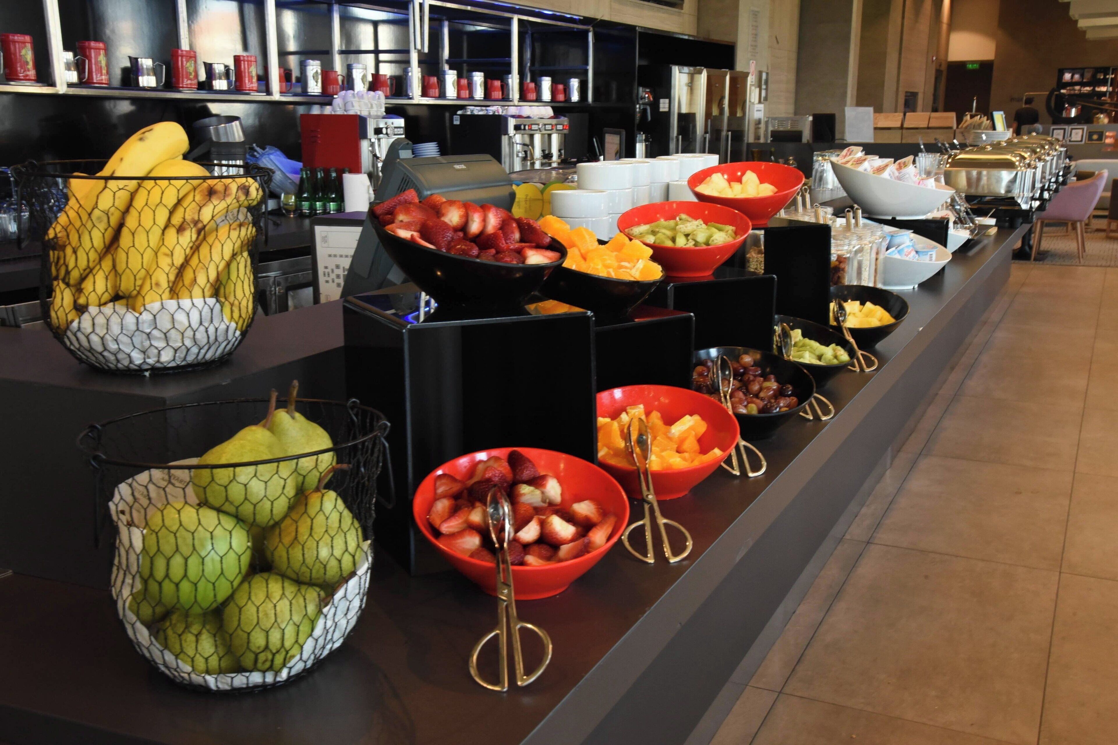 A buffet with various fruits and beverages.