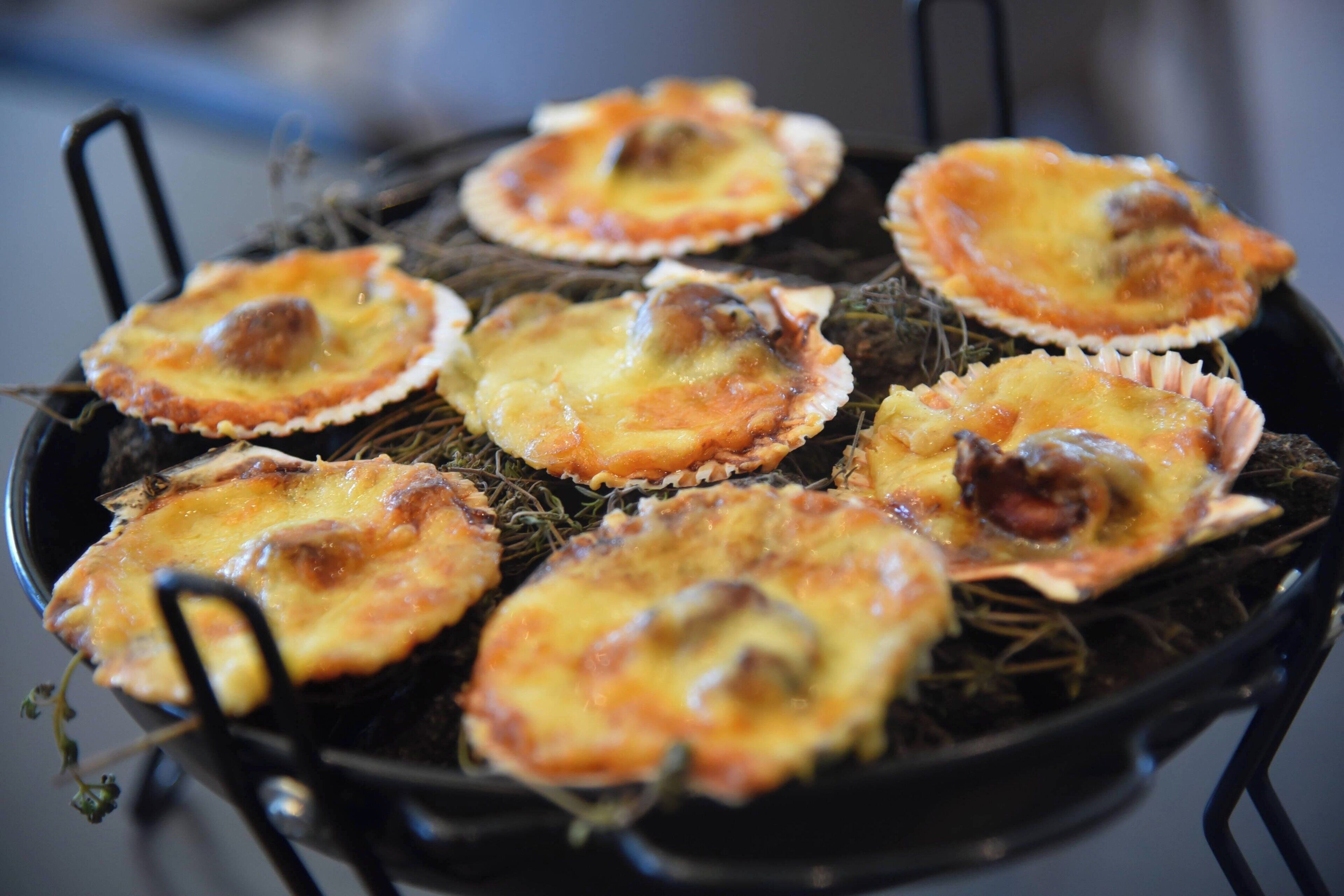 A grill with several food items, likely seafood, arranged on it.