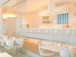 Un espace bar moderne avec des tabourets de bar blancs et un présentoir à vin.
