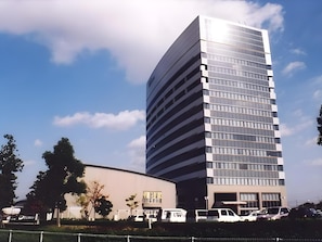 Un edificio moderno con fachada de vidrio y un aparcamiento en la planta inferior.