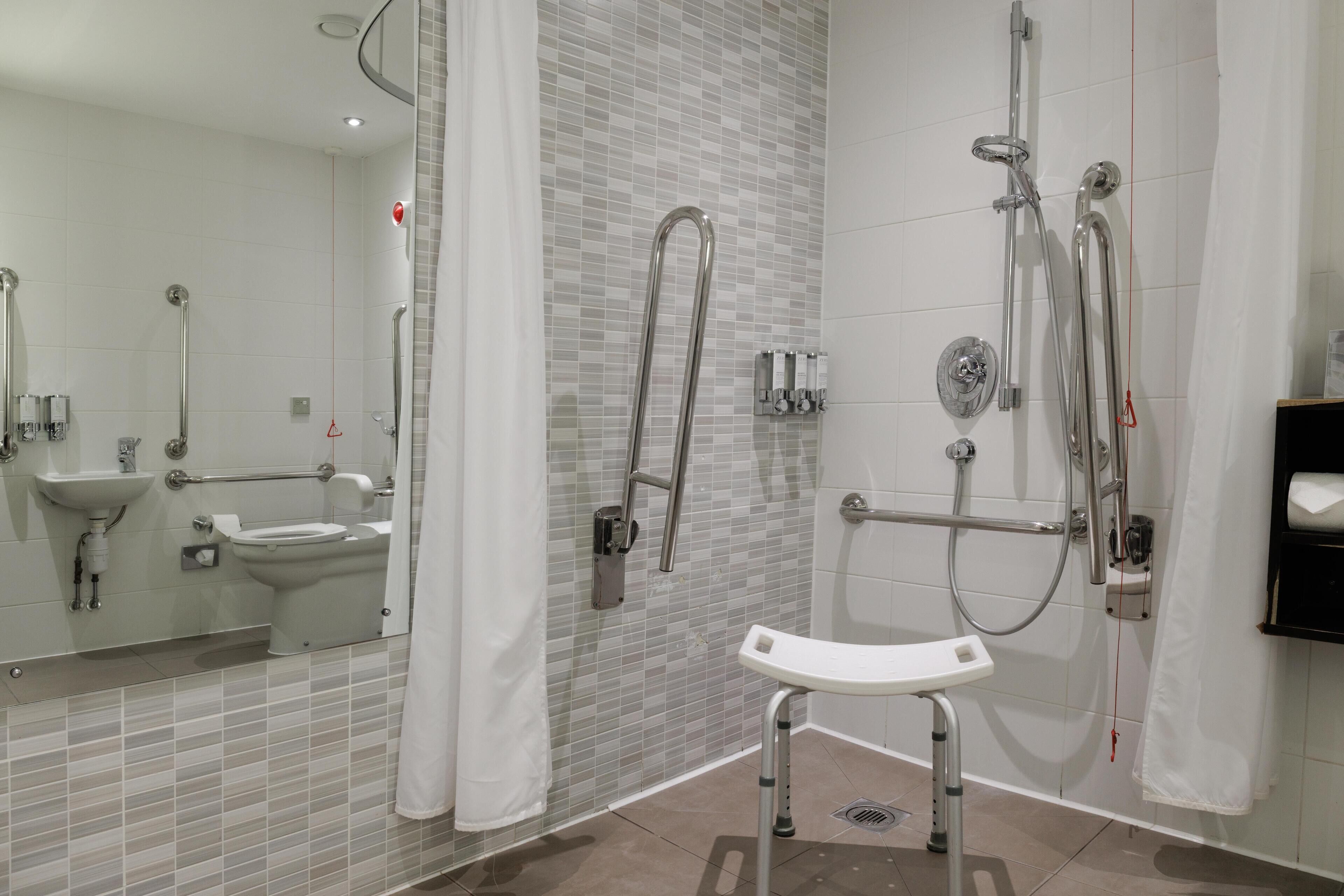 A modern bathroom with a glass shower enclosure, a white sink, and a toilet.