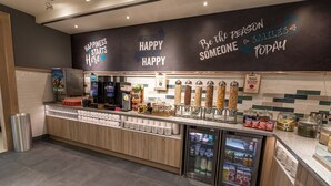 A self-service beverage station with dispensers, refrigerated drink options, and a variety of snacks.