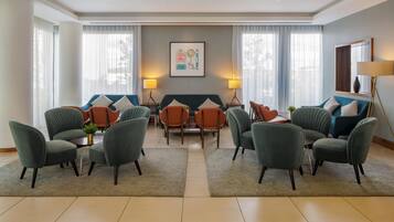 Un vestíbulo de hotel con zona de estar, chimenea y un ventanal grande.