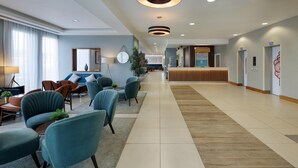 A spacious lobby with modern seating, a reception desk, and a clear pathway.