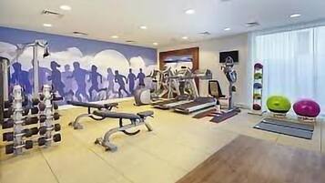 A gym with treadmills, weights, and exercise balls.