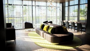 A modern living room with a sofa, chairs, and a dining area. - Kawagoe Tobu Hotel (Kawagoe)