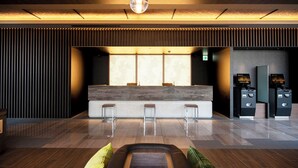 A modern reception area with a wooden reception desk, three bar stools, and a digital kiosk. - Kawagoe Tobu Hotel (Kawagoe)