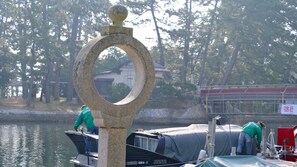 A stone structure with a circular top, a boat docked at a pier, and a person working on the boat.