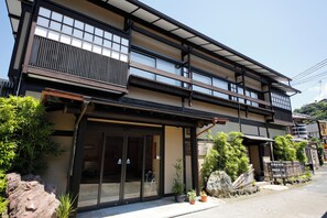 A traditional Japanese building with a modern entrance, large windows, and a balcony. - Cuisine Ryokan Toriki (Miyazu)