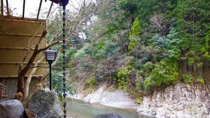 A natural outdoor setting with a stream, rocks, and a wooden structure. - Kamigoten Ryokan (Tanabe)