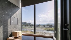 A modern bathroom with a large window, a wooden bench, and a marble-tiled wall. - Hitoyoshi Onsen Nabeya (Hitoyoshi)